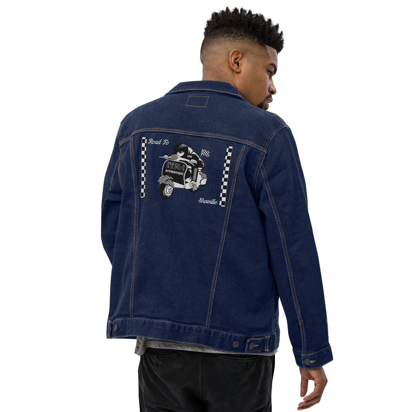 Man wearing a blue denim jacket with a graphic design on the back against a white background