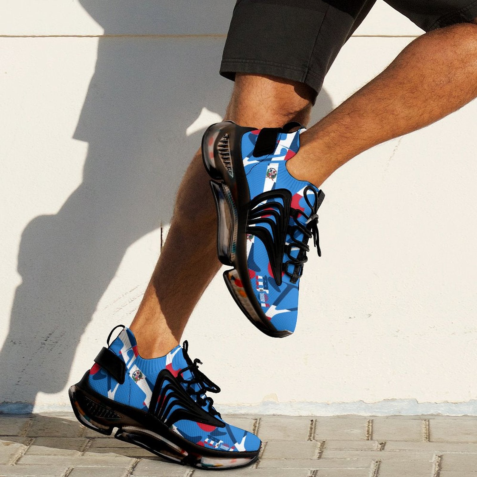 Blue and black sneakers with red accents worn by a person on a light background