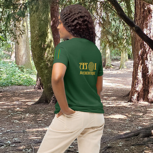 Person wearing a green t-shirt with 'Authentique' logo in a forest setting